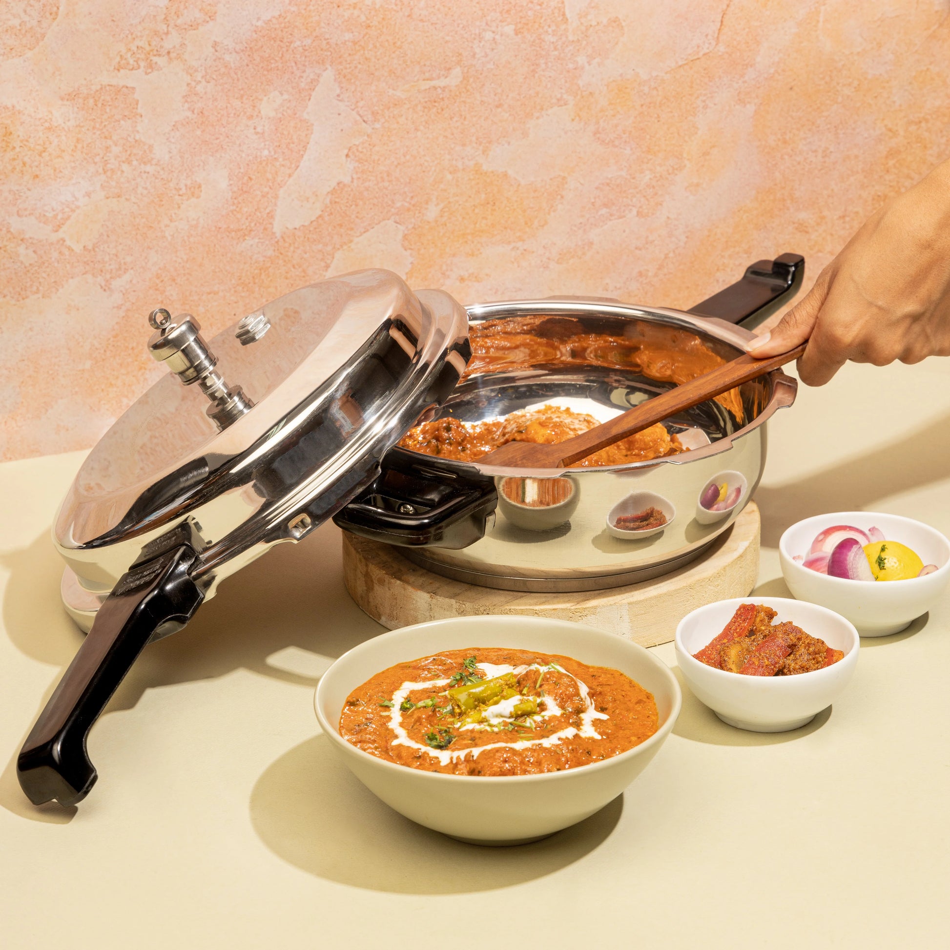 Pressure cooker with a wooden spatula, bowls of food