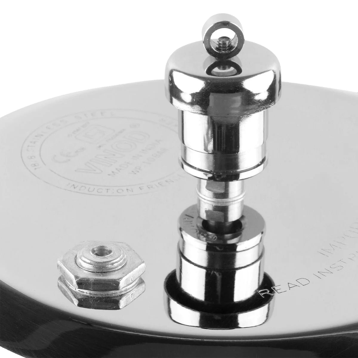 Close-up of a Stainless steel pressure cooker lid with a pressure regulator/vent weight