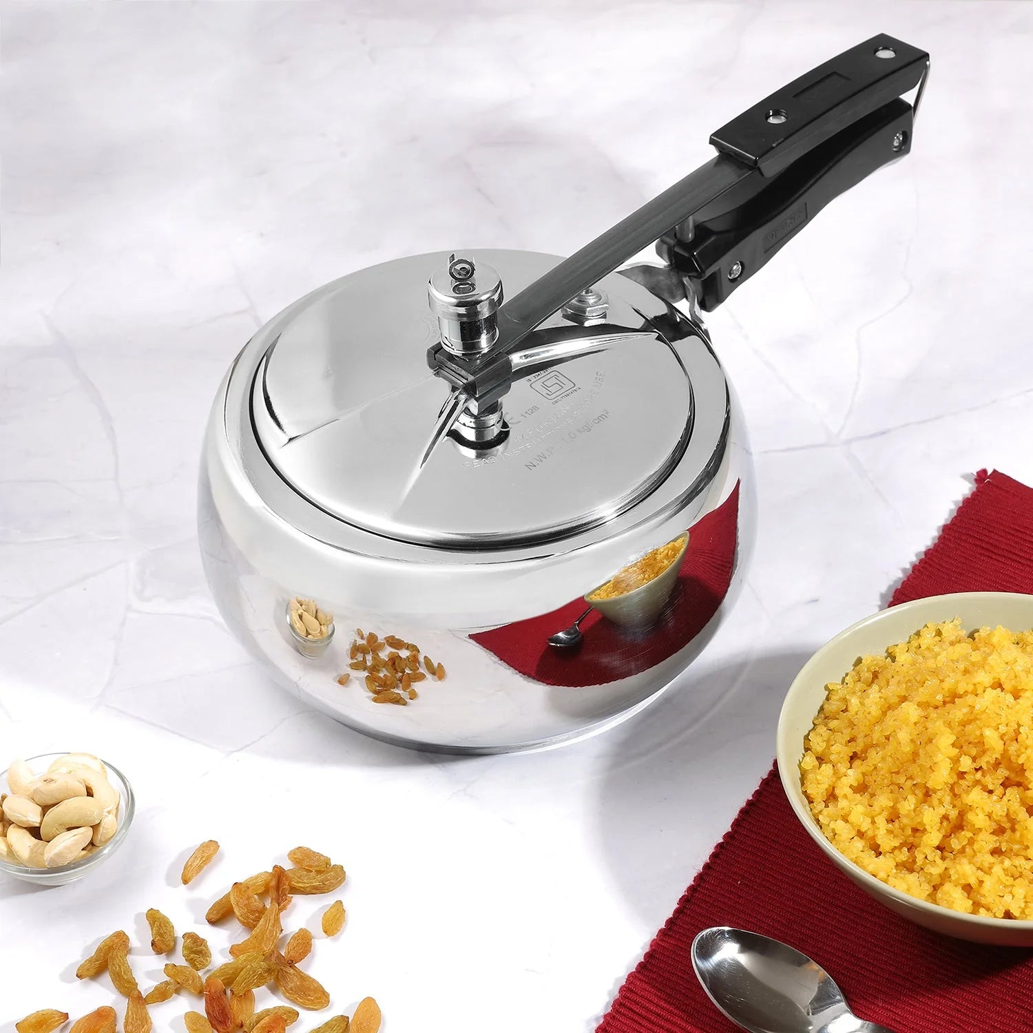3 liters Stainless steel pressure cooker with a bowl of yellow food and ingredients on a white background