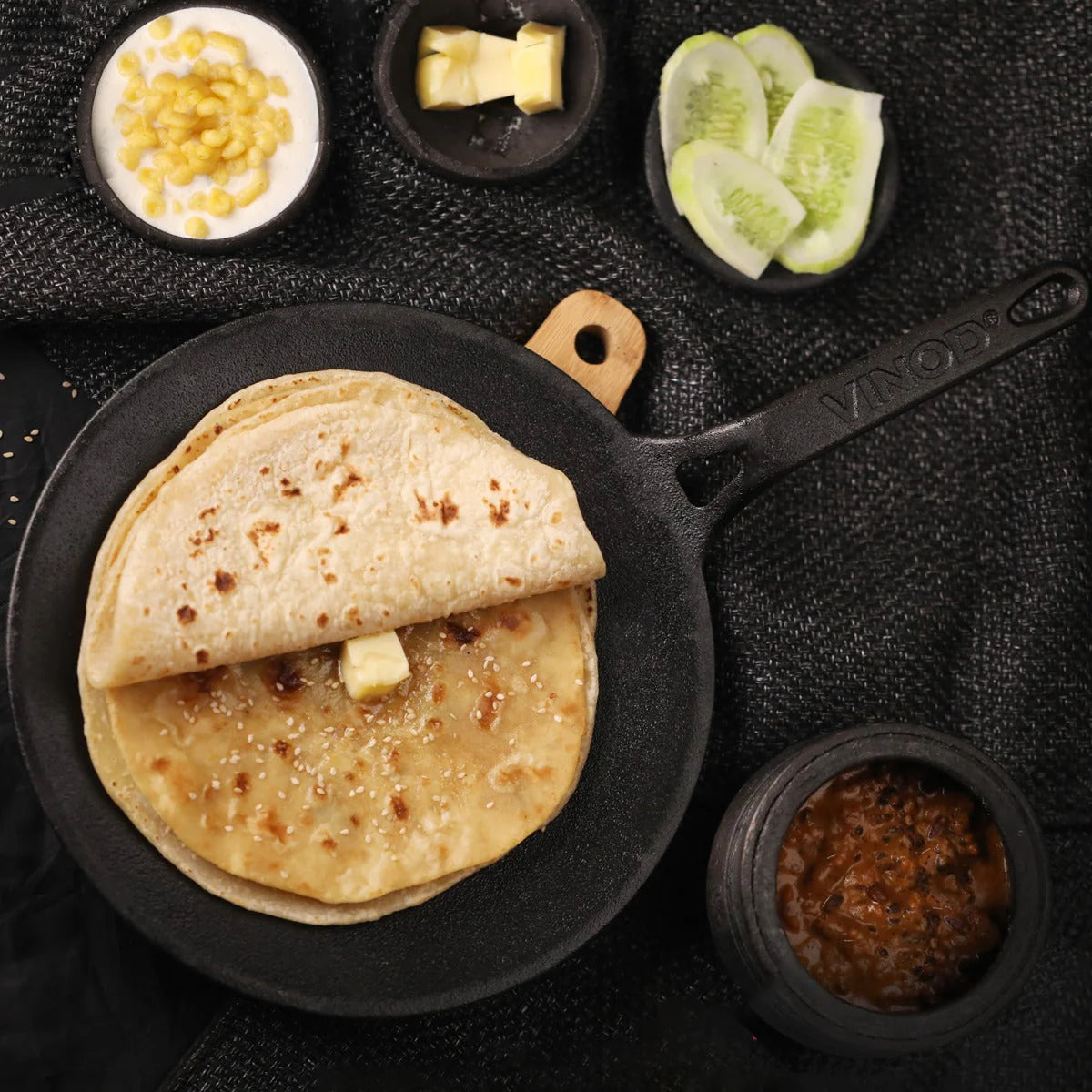 Vinod Legacy Pre-Seasoned Cast Iron Dosa Tawa 28 cm with a freshly made Chapati, garnished with butter