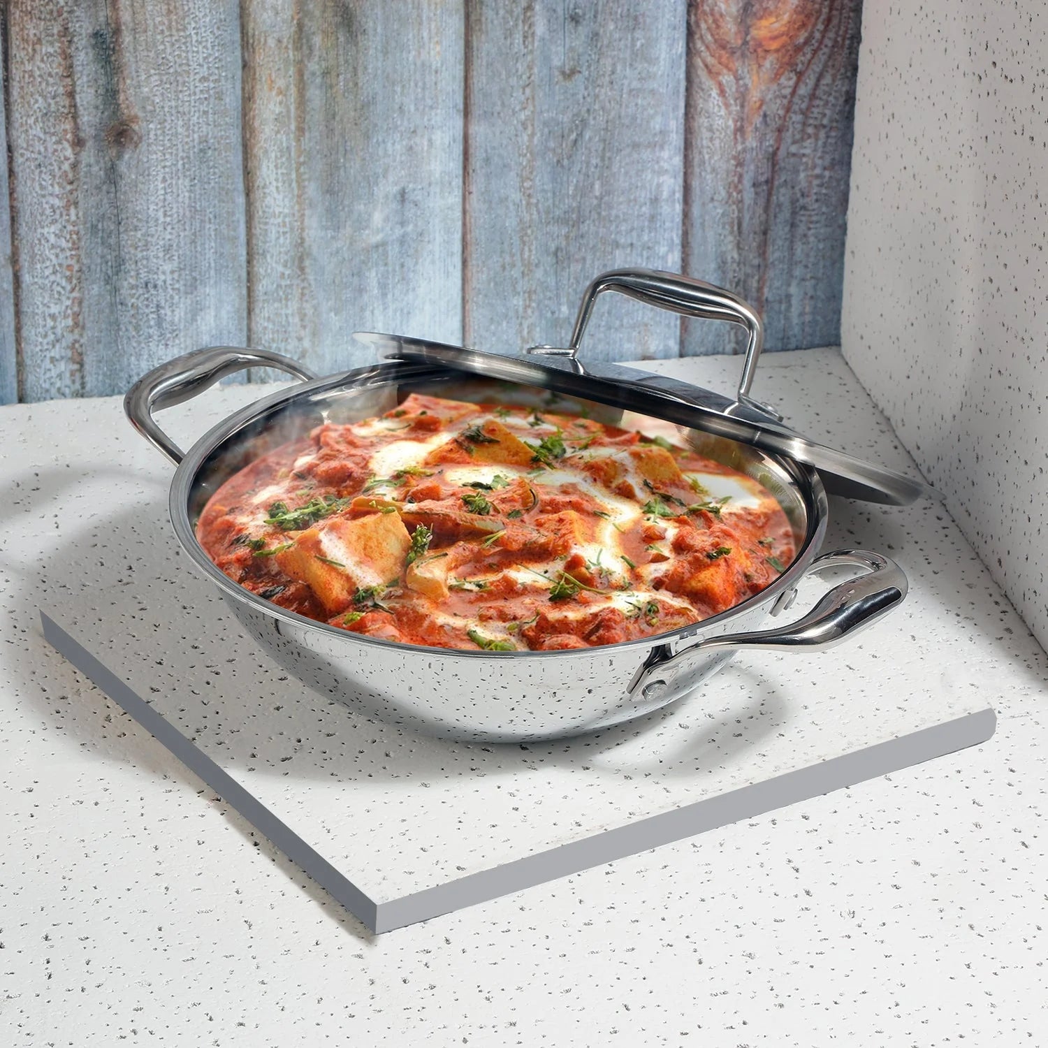 The Vinod Platinum SAS Pro Extra Deep Kadai filled with a steaming, generous portion of paneer curry, demonstrating its large capacity for cooking family-sized meals