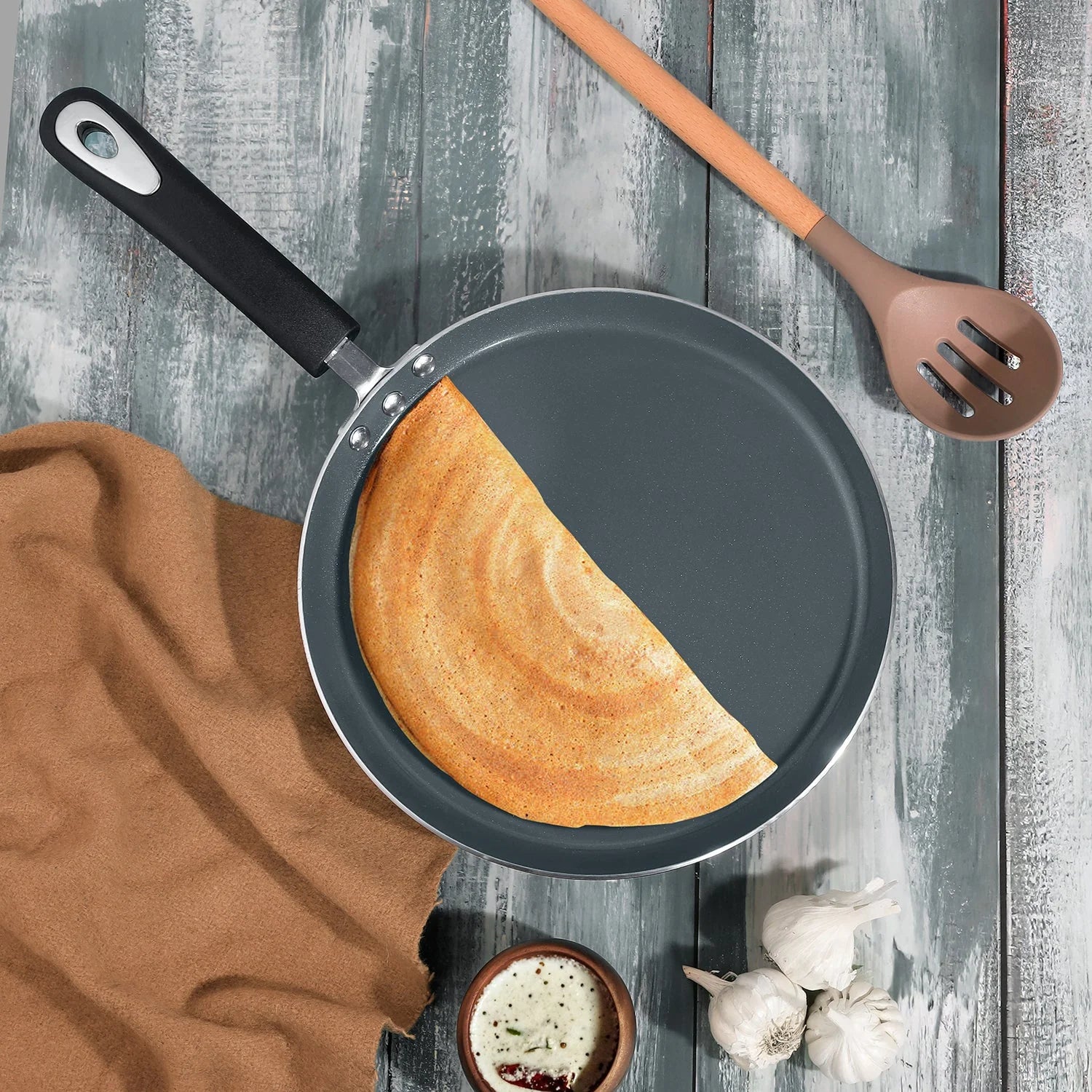 Perfect golden dosa being cooked in Vinod Zest Ceramica Dosa Tawa with heat-resistant black handle, showing excellent non-stick performance and cooking results